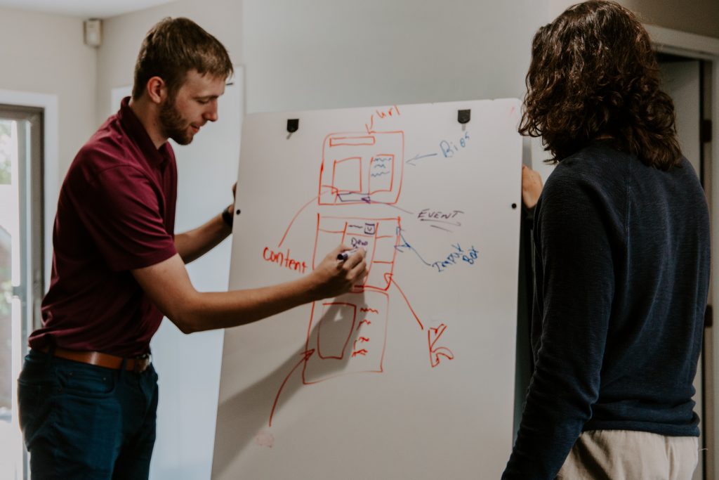 man writing on white board