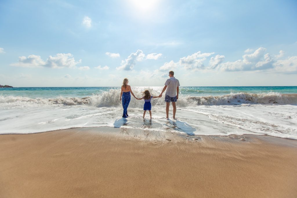 family walking in the seashore